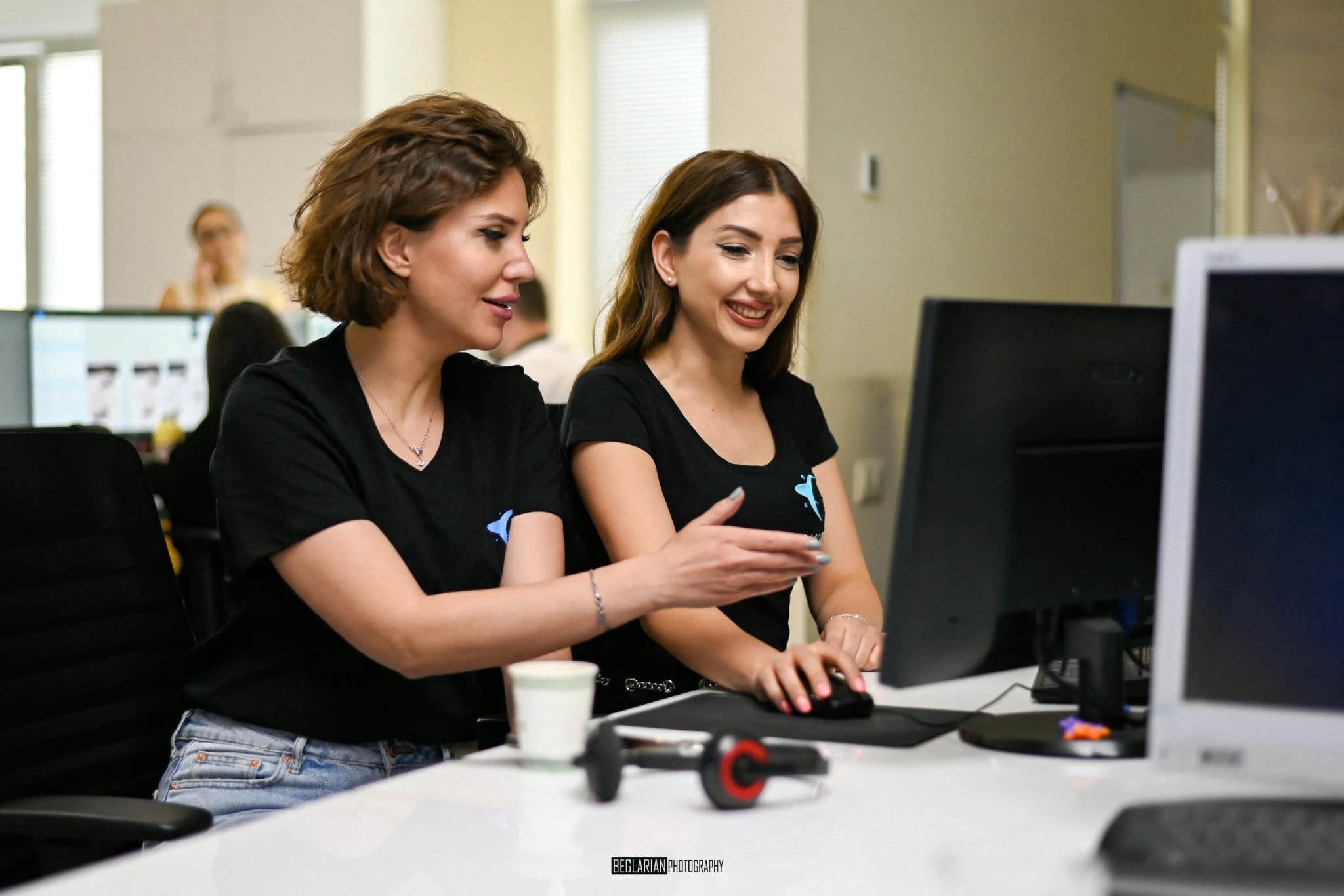 Two eWorld colleagues collaborating at a desktop computer
